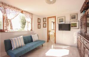 La Collina في أولبيا: غرفة معيشة بها أريكة زرقاء وتلفزيون
