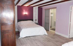 a bedroom with a bed with purple walls and a wooden floor at Gorgeous Home In Pleudihen Sur Rance in Mordreuc
