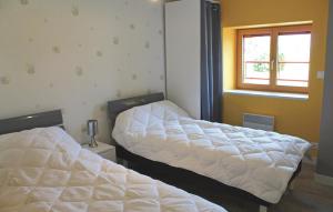 two beds in a room with a window at Gorgeous Home In Pleudihen Sur Rance in Mordreuc