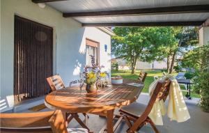 a wooden table and chairs on a patio at 2 Bedroom Pet Friendly Home In Medulin in Medulin