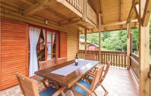 Lički Osik的住宿－Beautiful Home In Licki Osik With Kitchen，小屋门廊上的木桌和椅子