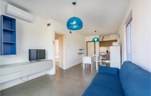 sala de estar con sofá azul y cocina en 2 Bedroom Lovely Apartment In Puegnago Sul Garda en Raffa