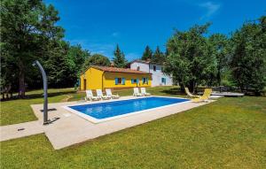 a yellow house with a swimming pool in a yard at Gorgeous Home In Nedescina With Kitchen in Nedeščina