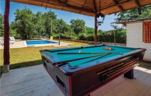 a pool table sitting on a deck next to a swimming pool at Gorgeous Home In Nedescina With Kitchen in Nedeščina