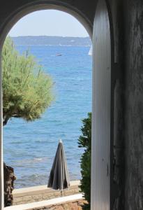 an ocean view from a window with an umbrella at La Belle Aurore - Les Collectionneurs in Sainte-Maxime