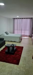 a bedroom with two beds and a red rug at Hermoso Apto Sector El Cable in Manizales