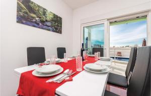 comedor con mesa y mantel rojo en Nice Home In Murvica With Kitchen, en Murvica