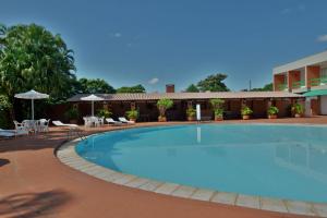a large swimming pool in front of a hotel at Hotel Deville Express Guaira in Guaíra
