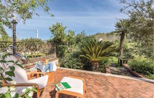 a patio with two chairs and a palm tree at Gorgeous Apartment In Castellabate Sa in Castellabate