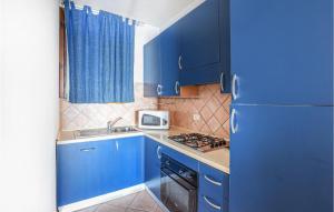 een blauwe keuken met een wastafel en een koelkast bij Casa Costa Verde in Arbus