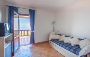 een woonkamer met een bank, een tv en een balkon bij Casa Costa Verde in Arbus