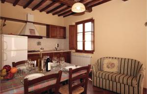 uma cozinha com uma mesa com copos de vinho e um sofá em Beautiful Apartment In Montaione fi With Outdoor Swimming Pool em Querce