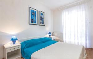 - une chambre blanche avec un lit bleu et 2 tables de chevet dans l'établissement Cozy Apartment In Rabac With Wifi, à Rabac