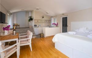 a bedroom with a bed and a table and a kitchen at Beautiful Home In Lopud With House Sea View in Lopud