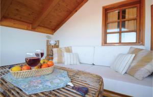 a white couch with a table with a basket of fruit at Stunning Home In Kukljica With Wifi in Kukljica