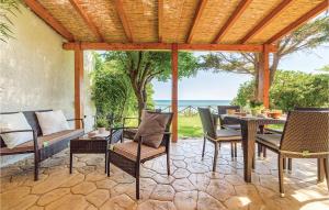 an outdoor patio with a table and chairs and the ocean at Gorgeous Home In Menfi Ag With Wifi in Porto Palo