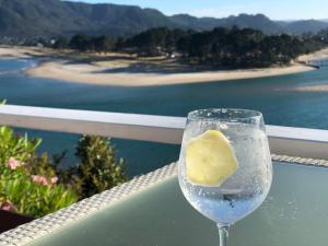 a glass of water with a lemon in it on a balcony at Tairua Treasure on Mount Paku in Tairua