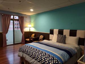 una camera da letto con un letto con una parete blu di 知本溫泉の旅宿 a Wenquan