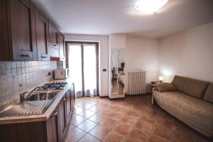 una cucina con lavandino e un divano in una camera di Residence Aquila - Mono Chamousira a Brusson
