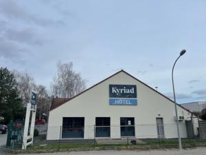 a white building with a hotel sign on it at Kyriad Meaux Sud Nanteuil Les Meaux in Nanteuil-lès-Meaux