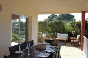 a patio with a table and chairs on a porch at Villas CALA CORSA 4 Chambres Piscine privée chauffée - Internet Fibre - Entièrement Climatisée à Lecci de Porto-Vecchio Cala Rossa in Lecci
