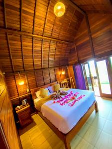 a bedroom with a large bed in a wooden room at Pinggan caldera in Baturaja