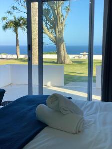 Santorini Guesthouse في امانزيمتوتي: غرفة نوم مع سرير وإطلالة على المحيط