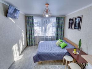 a bedroom with a bed and a table and a desk at YourHouse на Толе би Весновка in Almaty