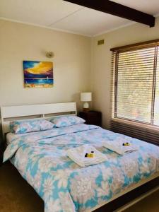 un dormitorio con una cama con dos animales de peluche en YOLO- Beach-house views, near penguins, nbn!, en Ventnor