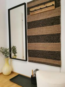 a mirror on a wall next to a vase at My TrIIIple Ferienwohnung zwischen City und Prater in Vienna