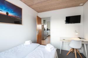 a bedroom with a bed and a desk with a computer at Hotel Frederikshavn in Frederikshavn
