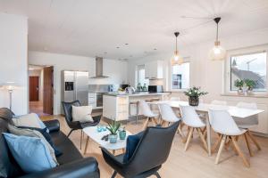 een keuken en een woonkamer met een tafel en stoelen bij Hotel Frederikshavn in Frederikshavn