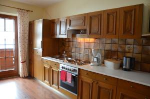 a kitchen with wooden cabinets and a stove top oven at Landhaus St. Georg in Sankt Martin am Tennengebirge