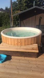 a hot tub sitting on a wooden deck at Le bain de la lesse in Tellin