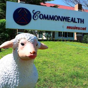 a statue of a sheep in the grass in front of a sign at โรงแรมคอมม่อนเวลธ์ Commonwealth Hotel&Resort in Suan Phung