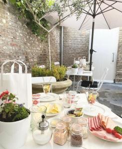 stół z talerzami jedzenia i parasolką w obiekcie Chambres D'Hotes Rekko w mieście Maastricht