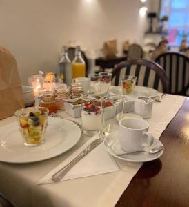 einen Tisch mit Teller mit Essen und Tassen darauf in der Unterkunft Chambres D'Hotes Rekko in Maastricht