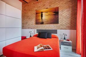 Un dormitorio con una cama roja con una pintura en la pared en Lovely & bright Bogatell beach apartment, en Barcelona