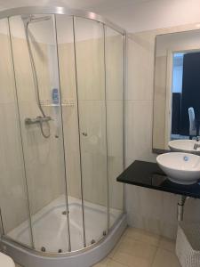 y baño con ducha y lavamanos. en Casas de Luanda GH-Miramar, en Luanda