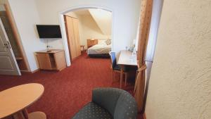 ein Hotelzimmer mit einem Bett, einem Tisch und Stühlen in der Unterkunft Hotel Rebmann in Leinsweiler