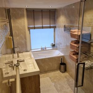 a bathroom with a tub and a sink and a window at All Exclusive Apartments in Dordrecht +43 photos