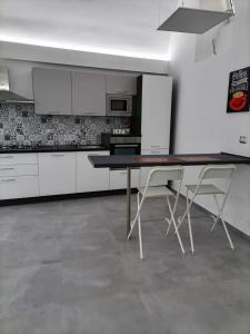 una cucina con tavolo e due sedie di Darsena Apartments a Molfetta