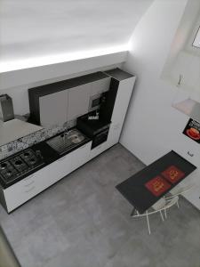 una cucina con piano cottura in bianco e nero e tavolo di Darsena Apartments a Molfetta