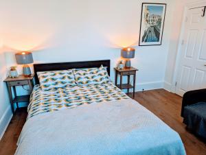 倫敦的住宿－TopHome Stoke Newington，一间卧室配有一张带2个床头柜和2盏灯的床。