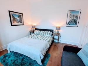 ロンドンにあるTopHome Stoke Newingtonのベッドルーム1室(ベッド1台、ランプ2つ、ソファ付)