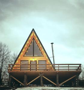 a house with a triangular roof on a wooden structure at CABANA 365 in Braşov