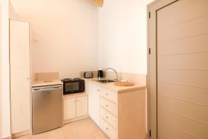 a small kitchen with a sink and a refrigerator at Marina Vista Luxury Studio suites Beach front in Corfu Town
