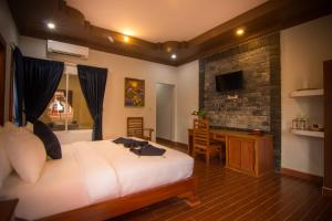 a bedroom with a bed and a desk in a room at RaVorn Villa Boutique in Battambang