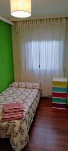 a small bedroom with a bed and a window at Apartamento vacacional en Brión, 15280 Río pego in Brion