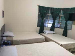 three beds in a room with a window at Hotel Mayesstic in Guatemala